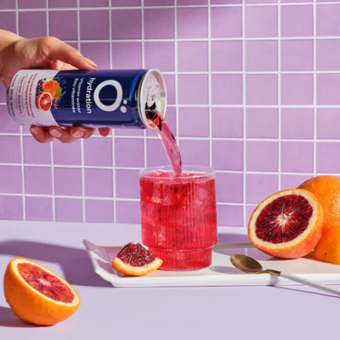 Eau vitaminée avec électrolytes & antioxydants - Orange sanguine & Cassis ohydration avec mains